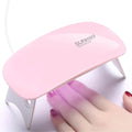 Pink mini UV LED nail lamp curing gel nails on hand